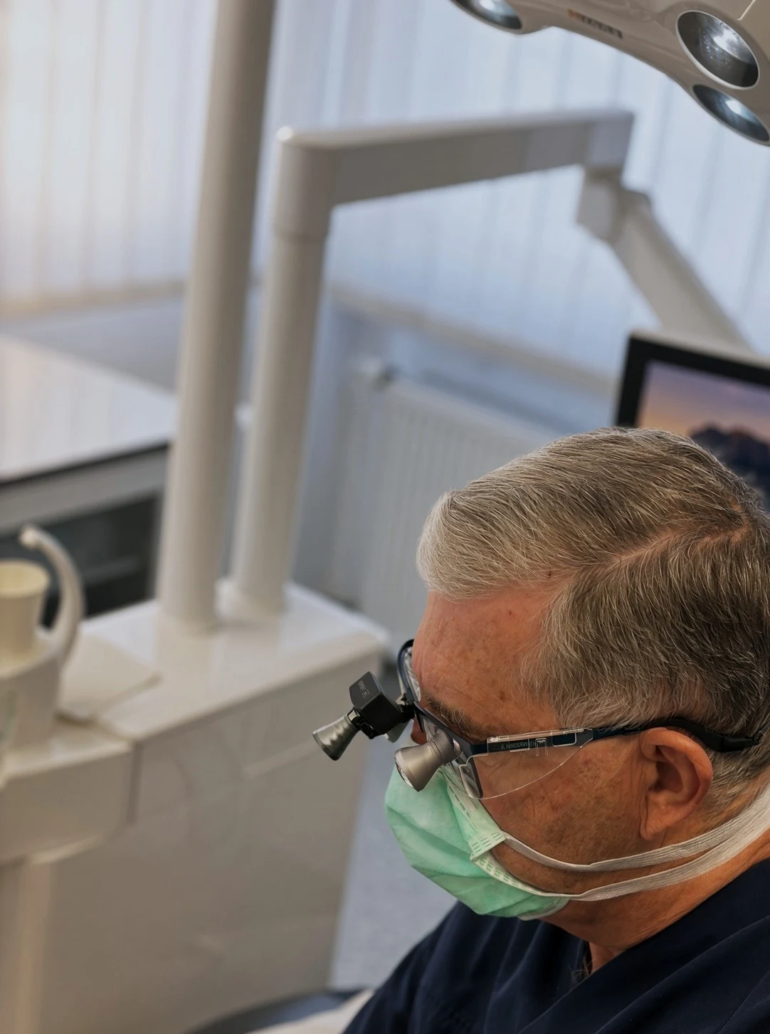 Dr. med. dent. Roland Handermann mit Lupenbrille bei der Behandlung in seiner Praxis in Speyer